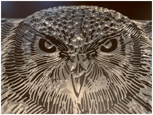 Detailed image of an owl scribed into finished material